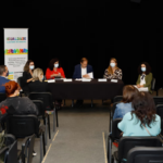 Sala onde decorreu o debate Da Estratégia Nacional aos Planos Municipais para a Igualdade. Potencialidades e Desafios colocados aos Municípios, com a presença da plateia e mesa de discussão.