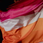 mulher segura bandeira lésbica nas costas
