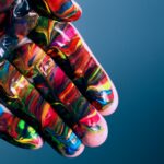 mão pintada com as cores das diferentes orientações sexuais para aludir ao tema da expressão de género e orientação sexual