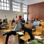 sala com pessoas sentadas assistem a formação