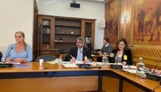 Sandra Ribeiro e Manuel Albano sentados a mesa com microfones e papeis.