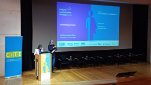 Fotografia do palco no momento da intervenação da presidente da CITE com o interprete de língua gestual