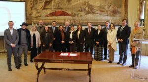 Fotografia de grupo com as e os representantes das entidades que assinaram o protocolo