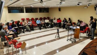 Fotografia do grupo de trabalho dispoto em formato de meia de lua