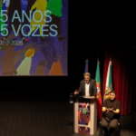 manuel albano discursa do púlpito, montado em cima do palco do auditório. ao seu lado, um intérprete de lingua gestual portuguesa