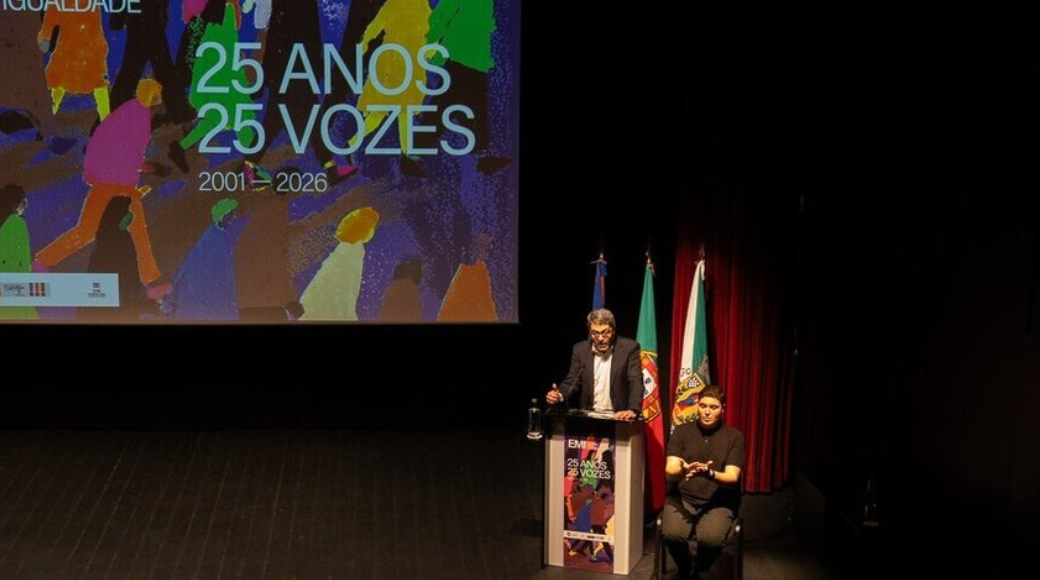 manuel albano discursa do púlpito, montado em cima do palco do auditório. ao seu lado, um intérprete de lingua gestual portuguesa