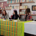 sentadas na mesa, presidente da cig carina quaresma, presidente da umar liliana rodrigues e coordenadora do projeto janica ndela
